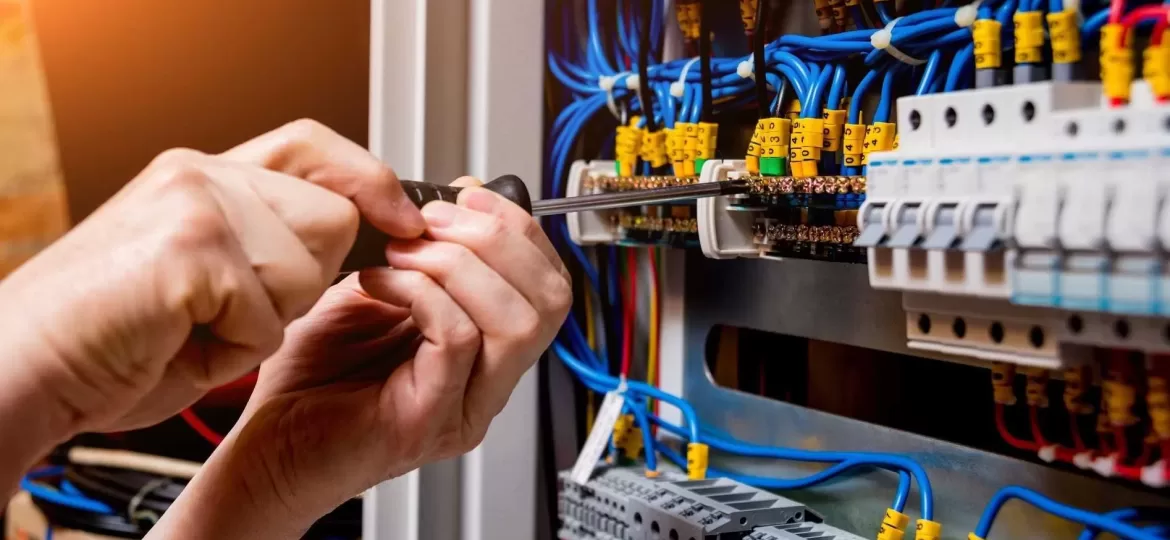 The man is repairing the switchboard voltage with automatic switches.